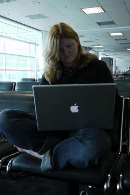 deb travel blogger working at airport